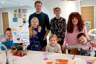 A family group smile after a family session at the Forget Me Not Centre holding up artwork they have created