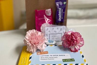 A image showing the contents of a hug bag, with sweet treats, a special book of letters, and activities